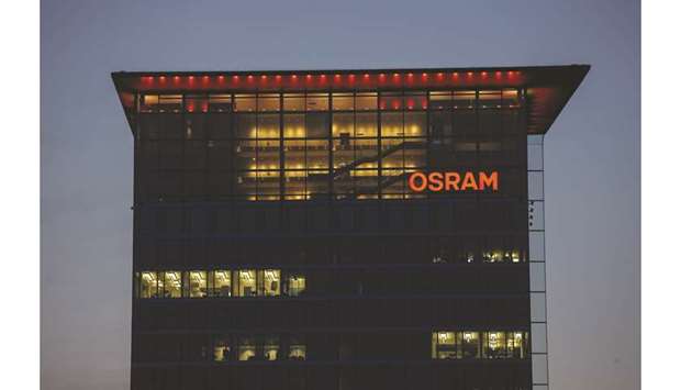 The Osram Licht logo and office windows are seen illuminated on the companyu2019s headquarters in the Skyline Tower in Munich. Osram investors tendered at least 55% of shares in favour of the bid, AMS said Friday in a statement.