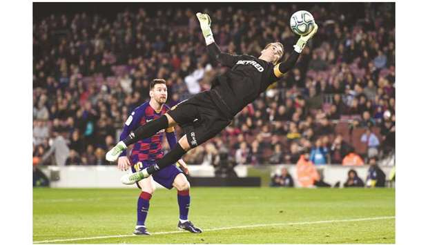 Barcelonau2019s Lionel Messi (left) looks at Real Mallorca goalkeeper Manolo Reina attempt a save during the La Liga match at the Camp Nou stadium in Barcelona, Spain, on Saturday. (AFP)