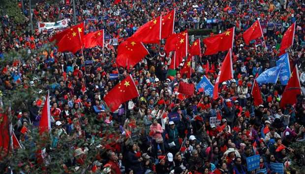 Pro-Beijing supporters wave Chinese national flags as they attend a rally in Hong Kong, China
