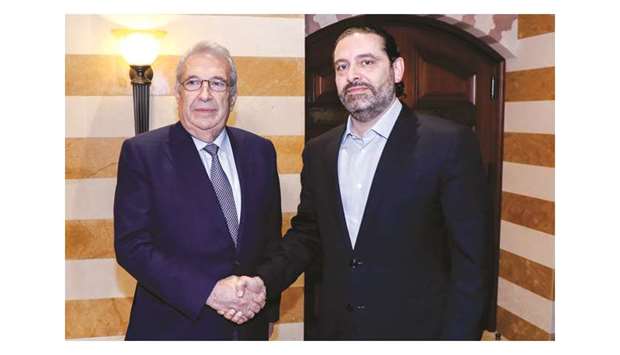 A handout picture provided by the Lebanese photo agency Dalati and Nohra yesterday shows outgoing Prime Minister Saad Hariri shaking the hand of Samir Khatib (left), a Lebanese businessman, in the capital Beirut.