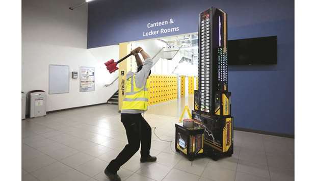 An employee hits a strength test academy machine at an Amazon.com fulfilment centre in Tilbury, UK. The Competition and Markets Authority has until tomorrow to decide whether to continue a two-month-old probe that froze Amazonu2019s bid of around $500mn for a minority stake in food-delivery service Deliveroo.