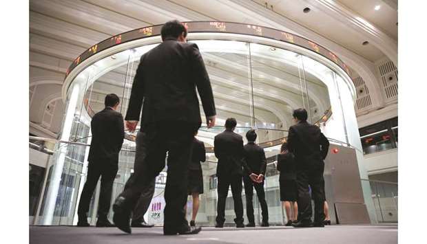 Visitors watch share prices at the Tokyo Stock Exchange in Japan. The Nikkei 225 closed up 0.3% to 23,430.70 points yesterday.