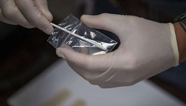 SAMPLE: A swab is used to take an initial trace sample of the substance in the bag.