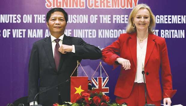 Vietnamu2019s Minister of Industry and Trade Tran Tuan Anh (left) and Britainu2019s International Trade Secretary Liz Truss elbow bump after signing a free trade agreement between the two countries in Hanoi yesterday. The deal with Vietnam comes into force January 1, 2021, and will be Britainu2019s third, following Thursdayu2019s pact with Singapore and Octoberu2019s first post-Brexit trade deal with Japan.