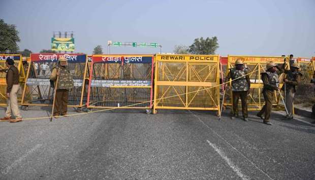 Police personnel bock a highway on the Haryana-Rajasthan border to stop farmers from joining protest in Delhi against the recent agricultural reforms, in district Rewari
