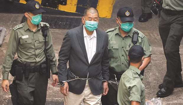 Media mogul Jimmy Lai Chee-ying, founder of Apple Daily, walks to a prison van to head to court, after being charged under the national security law, in Hong Kong, yesterday.