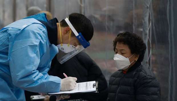 A medical worker talks with a woman who is undergoing a coronavirus disease test at a testing site in Seoul, South Korea