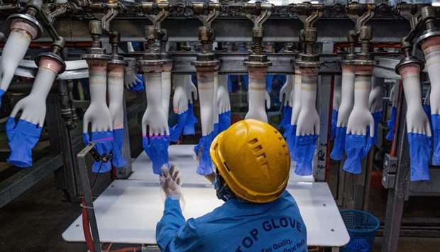 A worker inspects disposable gloves at the Top Glove factory production line in Shah Alam on the outskirts of Kuala Lumpur on August 26.