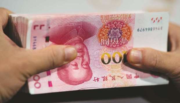 An employee counts out 100 yuan notes at a bank in Shanghai (file). The currency has been on a tear since late May, surging to a more than two-year high as data showed that Chinau2019s economy was rebounding from the virus pandemic.