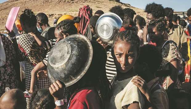 Ethiopian refugee children who fled the Tigray conflict wait in a line for a food distribution by Muslim Aid at the Um Raquba refugee camp in Sudanu2019s eastern Gedaref state.