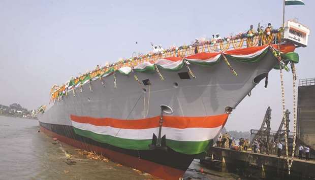Officials and shipyard workers wave from aboard the stealth frigate u2018Himgiri,u2019 after its launch ceremony into the Hooghly River in Kolkata, yesterday.