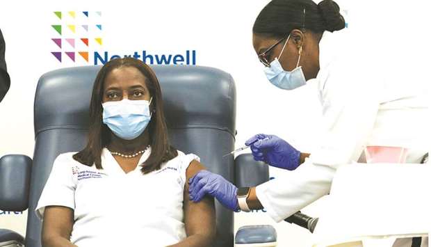 Sandra Lindsay, a nurse at Long Island Jewish Medical Centre, is inoculated with the Covid-19 vaccine by Dr Michelle Chester from Northwell Health, in New York.