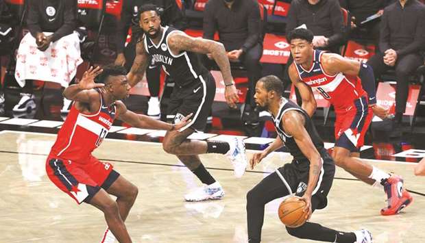 Kevin Durant (second from right) of the Brooklyn Nets dribbles the ball during the pre-season game against Washington Wizards at Barclays Center in the Brooklyn borough of New York City, United States, on Sunday. (AFP)