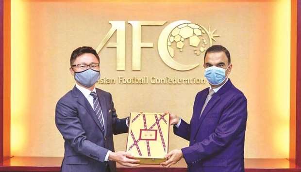 Qataru2019s Ambassador to Malaysia Fahd bin Mohammed Kafoud (right) hands over the final part of the bid documents for the 2027 AFC Asian Cup to an Asian Football Confederation official.