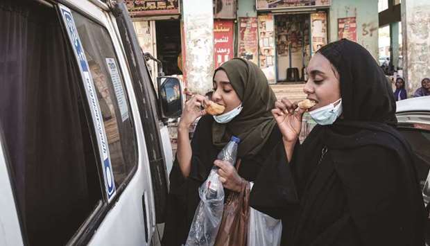 Sudanese women eat fried bread in the capital Khartoum, yesterday.
