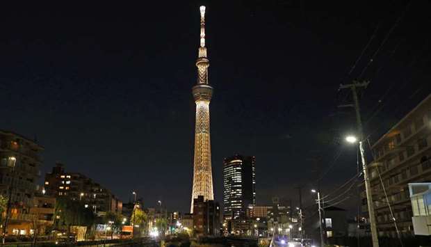 The Tokyo Skytree is illuminated with the colour of the Olympic Torch to mark 100 days until the start of torch relay for the postponed Olympics, Tokyo