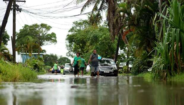Residents wade through the flooded streets in Fiji's capital city of Suva
