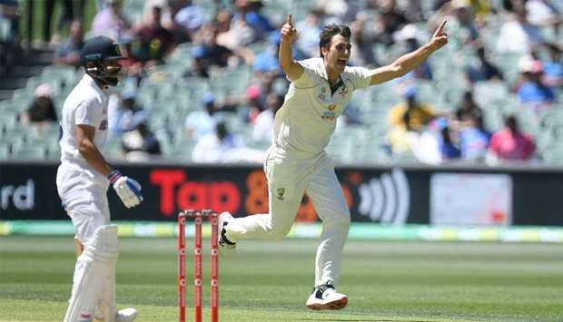 :Australian bowler Pat Cummins reacts after dismissing Indian captain Virat Kohli (L) for 4 runs on day 3 of the first test match between Australia and India at Adelaide Oval, Adelaide
