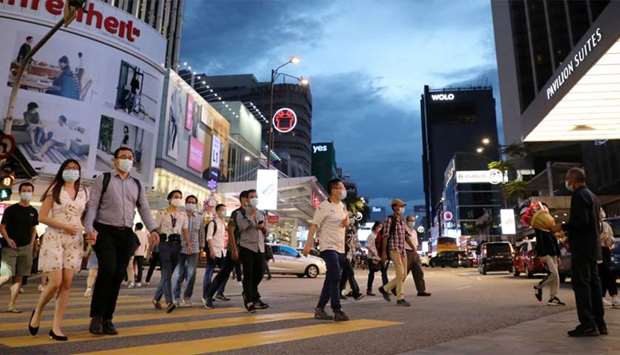 People wearing protective masks cross a street, amid the coronavirus disease (Covid-19) outbreak, in Kuala Lumpur