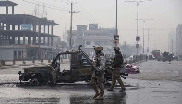 Members of the Afghan security forces stand at the site of an attack, in Kabul.