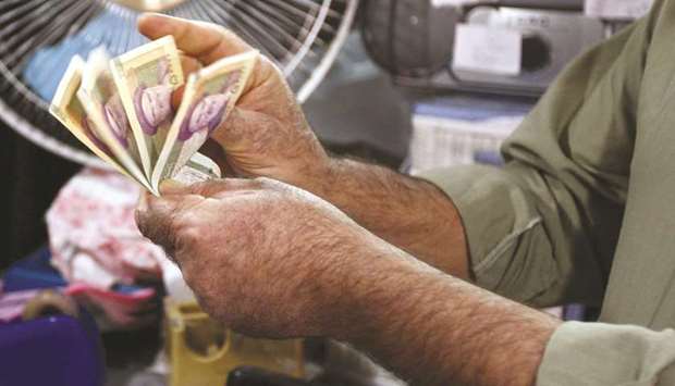An Iranian man counts rial 50,000 banknotes in a shop in Tehran (file).
