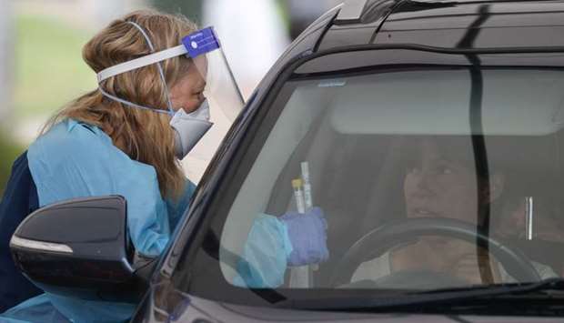 A medical worker speaks with a driver at the Bondi Beach drive-through coronavirus disease testing centre as the city experiences an outbreak in Sydney, Australia