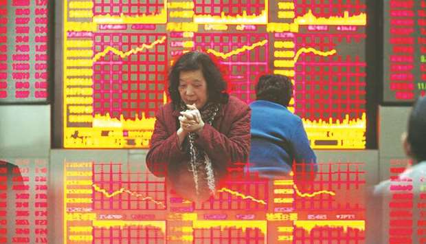 Investors monitor stock prices at a securities exchange firm in Shanghai. The Composite index closed 0.8% up at 3,420.57 points yesterday.