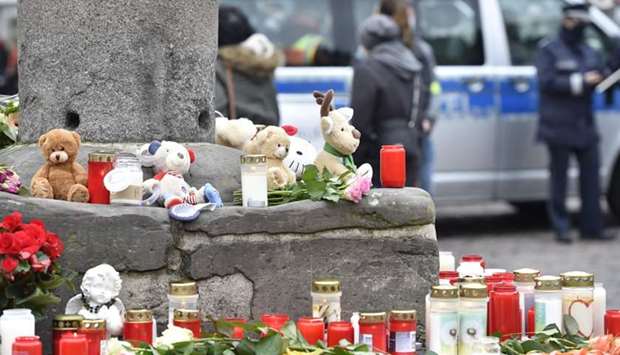Candles and flowers are placed at a makeshift memorial for the victims at the market column at Hauptmarkt square in Trier, southwestern Germany, one day after a car drove into pedestrians