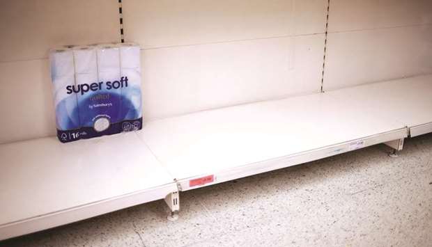 Toilet paper rolls are seen on an almost-empty shelf at a Sainsburyu2019s store in London yesterday.