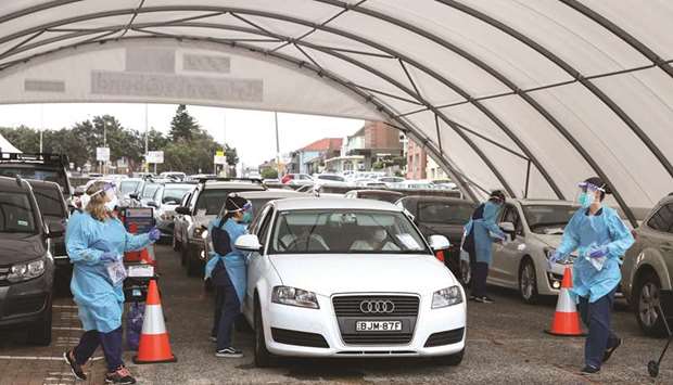 Vehicles queue while medical personnel administer tests for the coronavirus disease (Covid-19) at the Bondi Beach drive-through testing centre as the city experiences an outbreak in Sydney, yesterday.