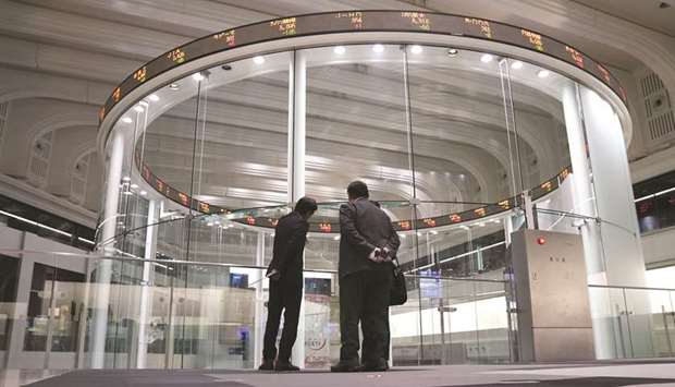 Visitors stand in front of an electronic ticker at the Tokyo Stock Exchange. Japanese robo-adviser WealthNavi debuted on the TSE yesterday in one of the biggest initial public offerings on the bourse this year.