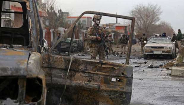 A member of Afghan security force stands guard at the site of an attack in Kabul on December 20