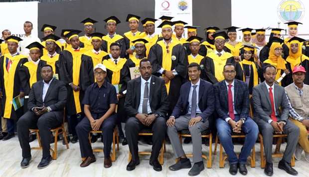 Some of the graduates sponsored by QC are seen with officials at the ceremony