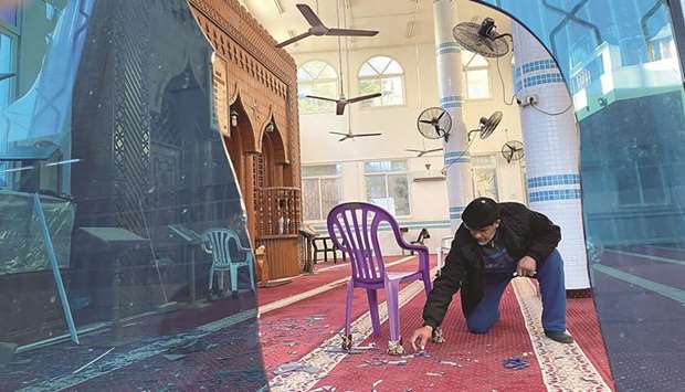 A Palestinian man shows to media broken glass in a mosque damaged after an air strike in Gaza City, yesterday.