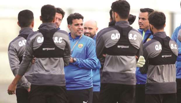 Qatar SCu2019s Younis Ali talks to his players at a training session yesterday.