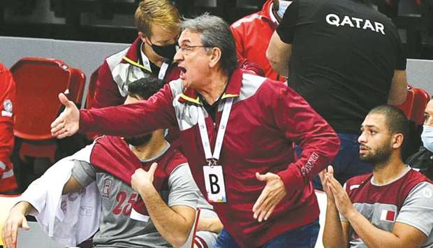 Qatar coach Valero Rivera gives instructions to his players.