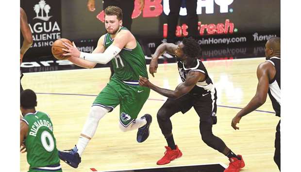 Dallas Mavericks guard Luka Doncic (left) is fouled by Los Angeles Clippers guard Patrick Beverley as he drives to the basket in the second half of the NBA game at Staples Center in Los Angeles, United States, on Sunday. (USA TODAY Sports)