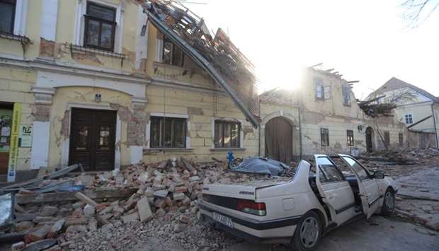 Destroyed houses and a car are seen on a street after an earthquake in Petrinja, Croatia
