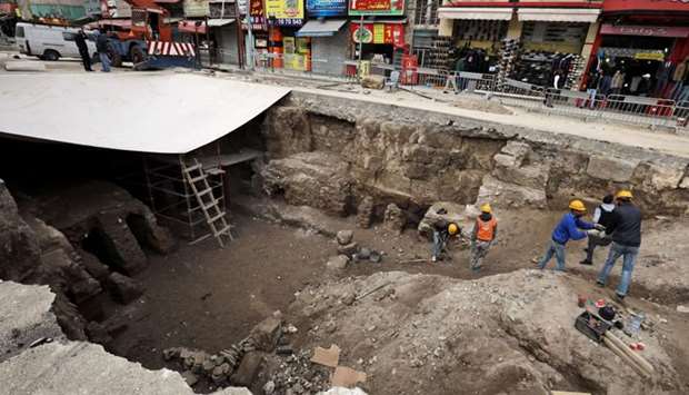 Archaeologists and workers excavate at a Roman archaeological site discovered during works to install a water drainage system, in downtown Amman, Jordan