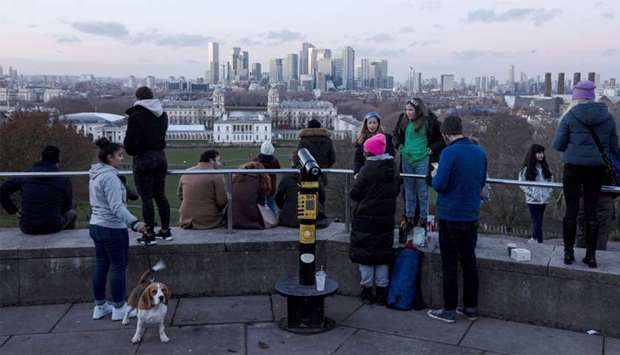 People look towards Canary Wharf from Greenwich Park in London, Britain