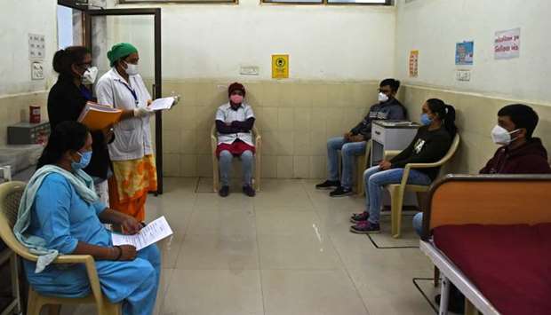 Health workers sit inside an observation room at the Public Health Centre (PHC) in Adalaj