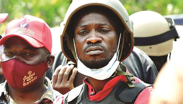 Ugandan opposition presidential candidate Robert Kyagulanyi also known as Bobi Wine (centre) is escorted by policemen during his arrest in Kalangala.