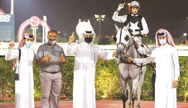 Jassim Mohamed Ghazali (centre) and connections celebrate after Alberto Sanna (second from right) rode AJS Wathanan to victory in The Late Rabiah Saad Al Kaabi Cup yesterday.