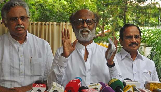 Indian actor Rajinikanth (C) addresses the media representatives in front of his residence in Chenna