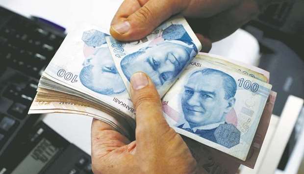 A money changer counts Turkish lira banknotes at a currency exchange office in Istanbul (file).