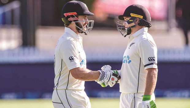 New Zealandu2019s captain Kane Williamson (L) shakes hands with Tom Latham during the first day of the first Test cricket match against West Indies at Seddon Park in Hamilton yesterday.