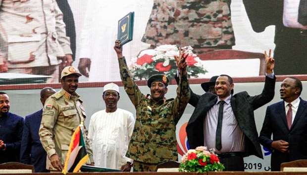 Sudan's protest leader Ahmad Rabie (2nd-R), flashes the victory gesture alongside General Abdel Fattah al-Burhan (C), the chief of Sudan's ruling Transitional Military Council (TMC), during a ceremony where they signed a ,constitutional declaration, that paves the way for a transition to civilian rule, in the capital Khartoum, accompanied by General Mohamed Hamdan Daglo ,Hemeti, (2nd-L), TMC deputy chief and commander of the Rapid Support Forces (RSF) paramilitaries, Ethiopian Prime Minister Abiy Ahmed (L), South Sudan President Salva Kiir Mayardit (2nd-R, behind), Chadian President Idriss Deby (3rd-L), and Kenyan President Uhuru Kenyatta (R). File picture: August 17, 2019