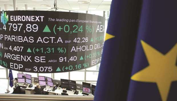 Share price information is displayed on a screen hanging over the Euronext Paris Stock Exchange trading floor.