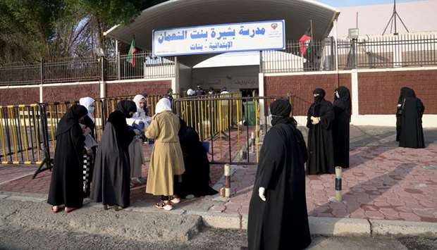 Kuwaiti women gather at the entrance of a polling station during parliamentary elections in Jahra City, Kuwait 
