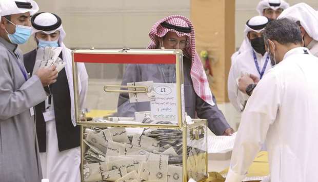 A Kuwaiti judge (centre) and his aides count the ballots at a polling station at the end of the parliamentary elections vote, in the  Abdullah al-Salem district of Kuwait city, yesterday.